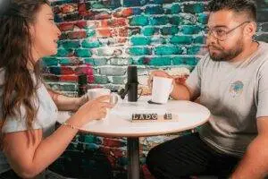 man in white crew neck t-shirt sitting beside woman in white crew neck t-shirt